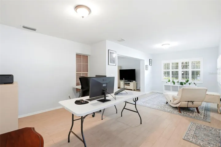 Florida room with office on one side and casual relaxing area in the back ground