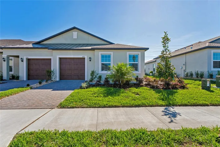 One car garage, paved driveway, and beautiful landscape.