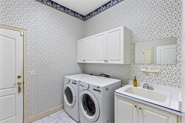 THE LAUNDRY ROOM IS POSITIONED WHEN YOU COME IN THROUGH THE GARAGE WITH A DEEP SINK AND WINE REFRIGERATOR.