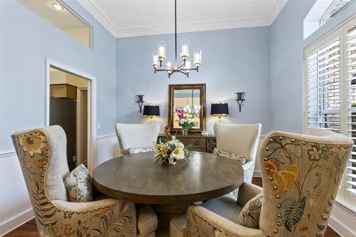 THE DINING ROOM WITH CROWN MOLDING AND PLANTATION SHUTTERS.
