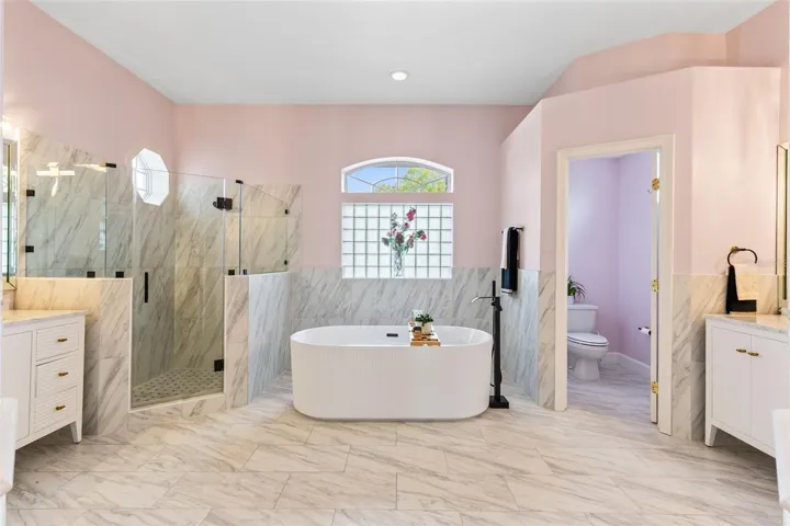 THE PRIMARY BATH HAS RECENTLY BEEN REMODELED TO INCLUDE THIS FREESTANDING TUB, LARGE SHOWER, DOUBLE VANITIES AND A PRIVATE WATER CLOSET.