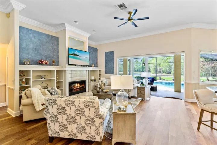 FAMILY ROOM WITH WOOD FLOORING AND OPENS UP TO THE POOL AND LANAI