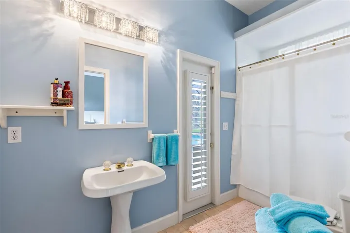 THE 4TH BEDROOM'S BATHROOM WITH DOOR OUT TO THE LANAI FOR THEIR OWN PRIVATE POOL ENTRANCE. THERE IS ALSO A LARGE LINEN CLOSET.