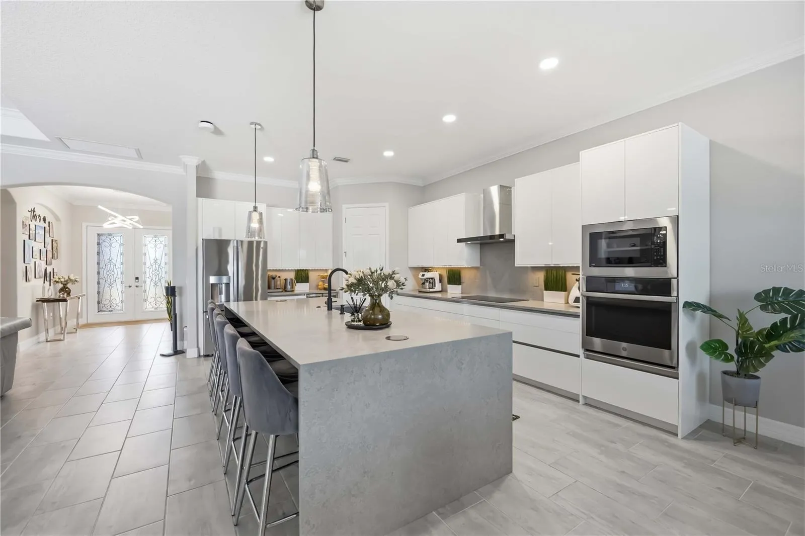 Kitchen Island has a waterfall quartz island, with upgraded plumbing in the island