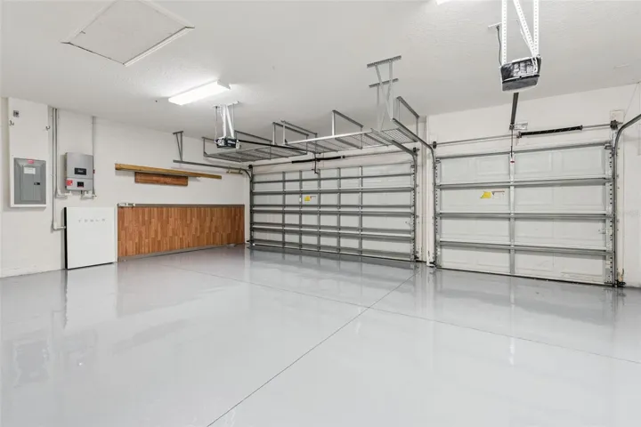 3 car garage with Tesla charger and overhead storage