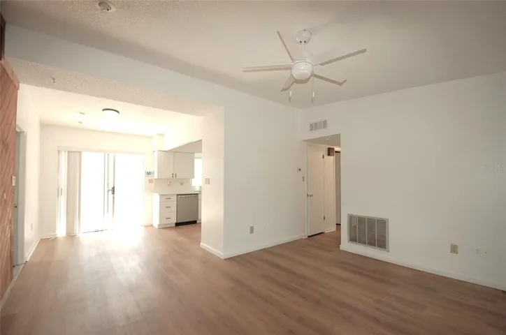 Living Room and dining room with cedar wood accent wall, new luxury vinyl flooring and vaulted ceilings.