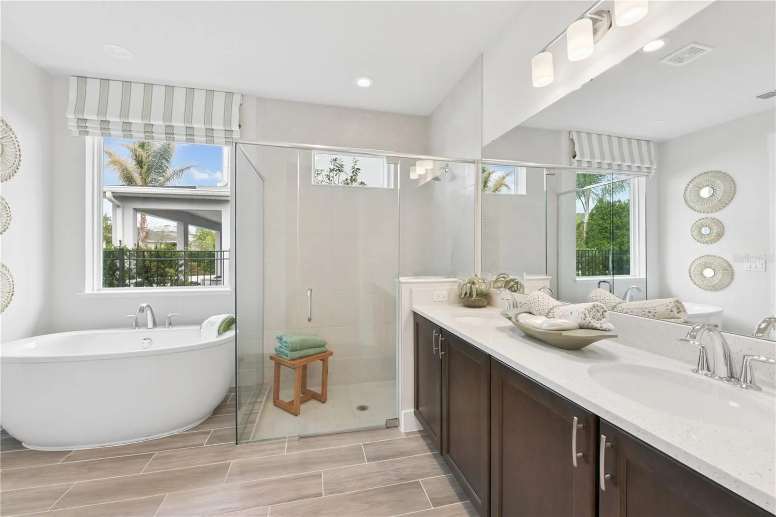 Spacious primary suite with soft, calming tones and a luxurious ensuite featuring a freestanding tub, walk-in shower, dual vanities, and walk-in closet.