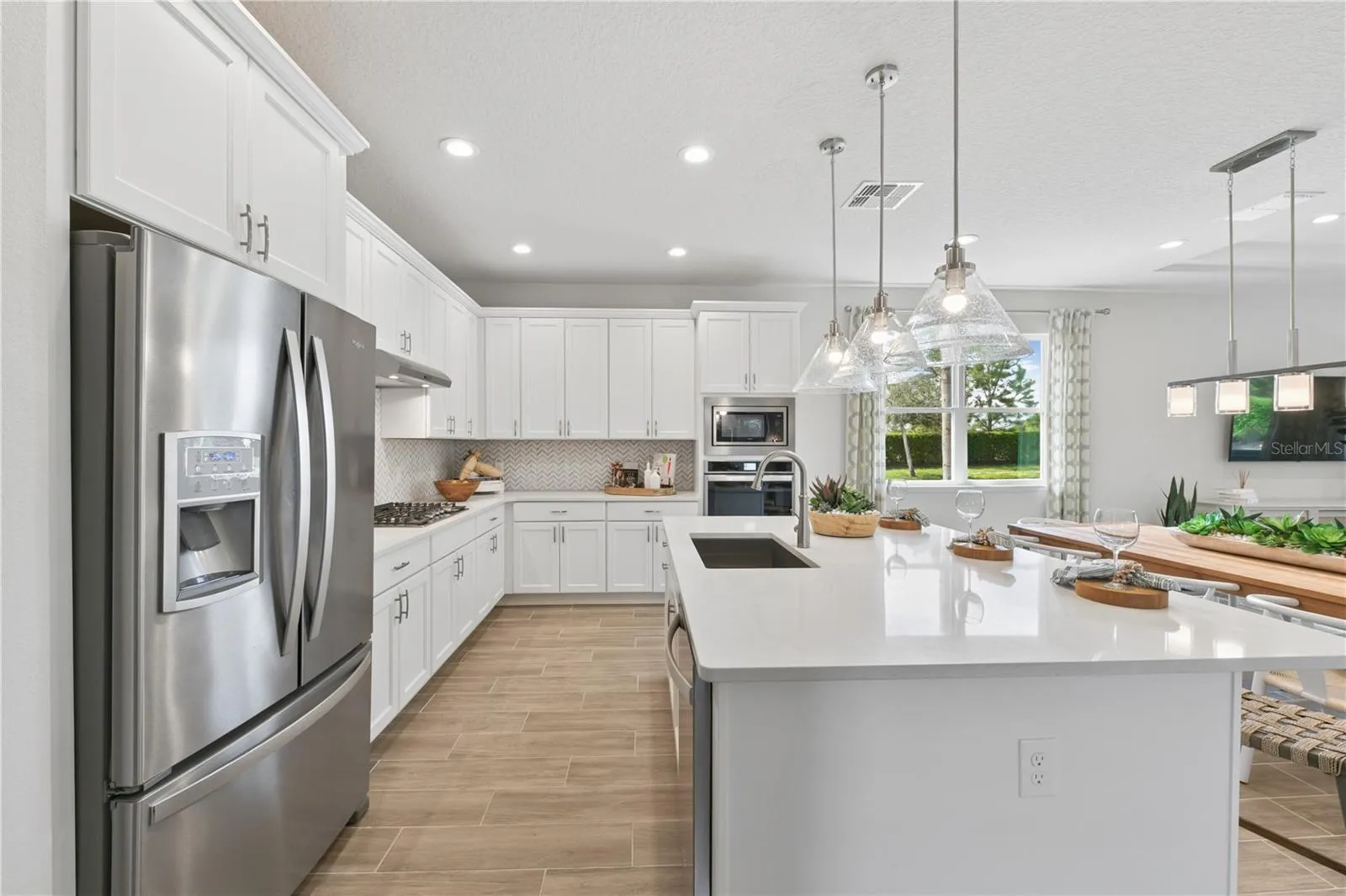 Bright gourmet kitchen with crisp finishes, light cabinetry, and natural textures for an effortless, airy feel.