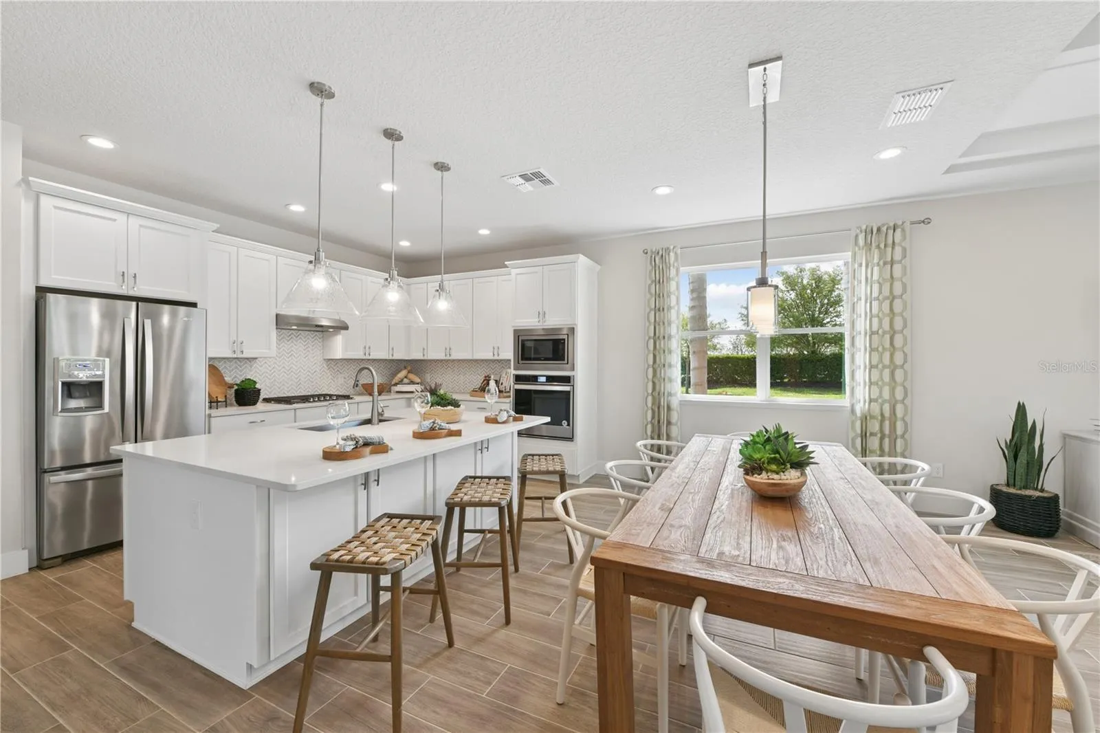 Bright gourmet kitchen with crisp finishes, light cabinetry, and natural textures for an effortless, airy feel.