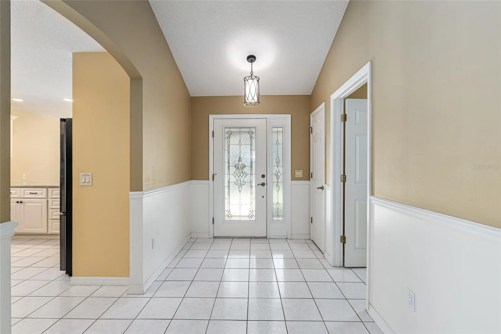 Foyer Reverse View: Entry hallway showcases high ceilings, classic wainscoting detail, and an open flow into the main living areas.