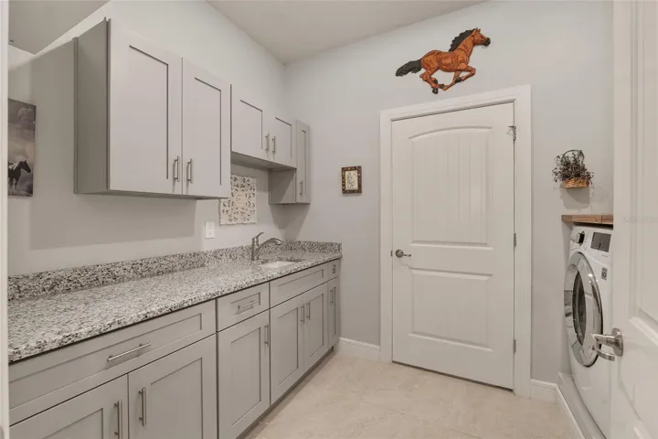 Laundry room with additional storage closet