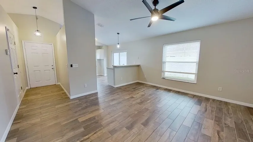 View from Living room to the foyer entry and Kitchen area.