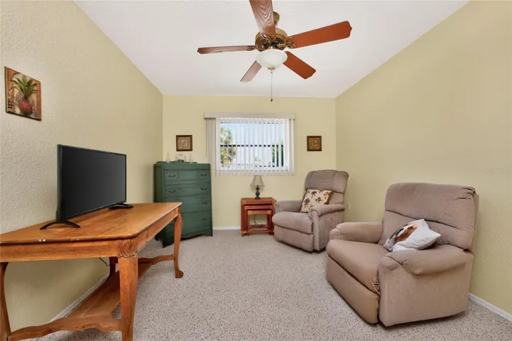 Bedroom #2 has berber carpeted flooring and a ceiling fan