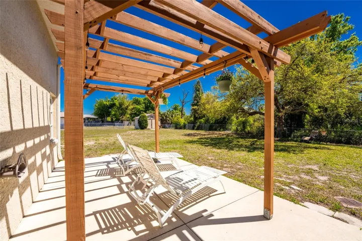 Pergola with concrete floor would be a great place to hang some plants!