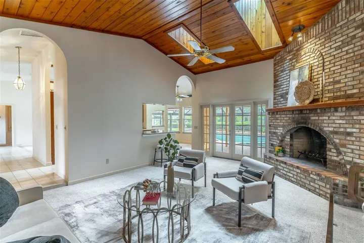 Family Room Showcases 2 Skylights, Wood-Burning Fireplace & French Doors Leading to Pool and Patio
