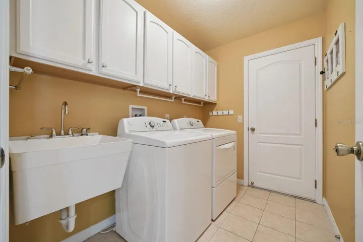 Laundry with slop tub & Maytag washer & dryer.