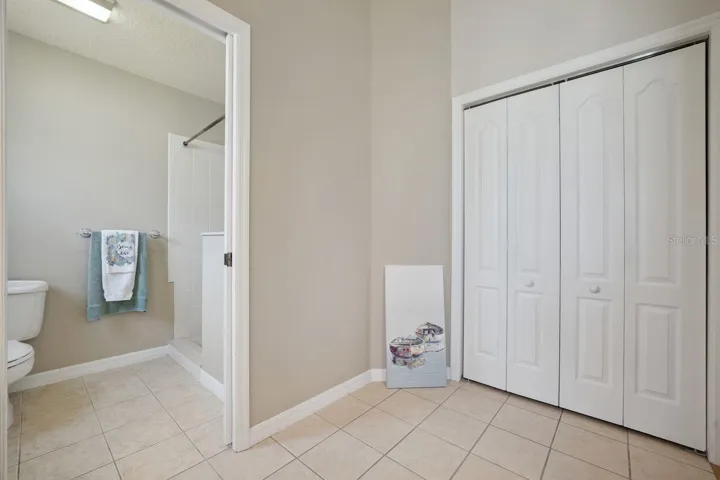 Master bathroom with vast linen closet. Showing a separate commode & shower area.