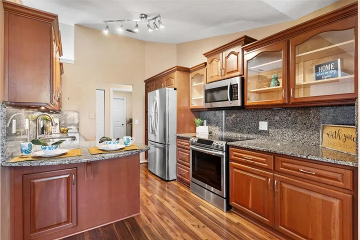 Kitchen features upgraded cabinets, granite countertops & backsplash, stainless steel appliances