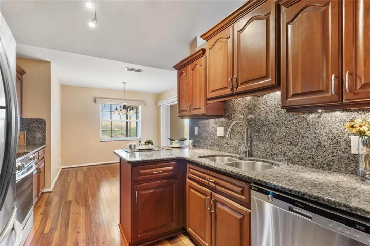 Kitchen features upgraded cabinets, granite countertops & backsplash, stainless steel appliances