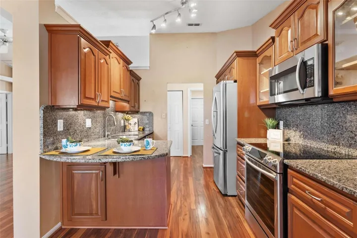Kitchen features upgraded cabinets, granite countertops & backsplash, stainless steel appliances