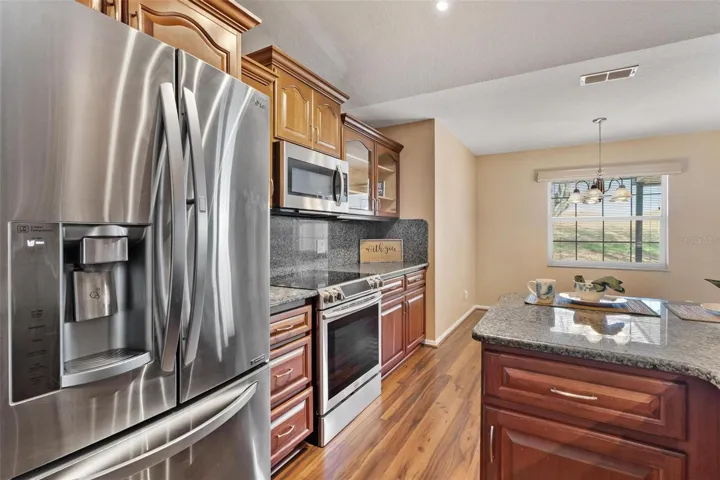 Kitchen features upgraded cabinets, granite countertops & backsplash, stainless steel appliances