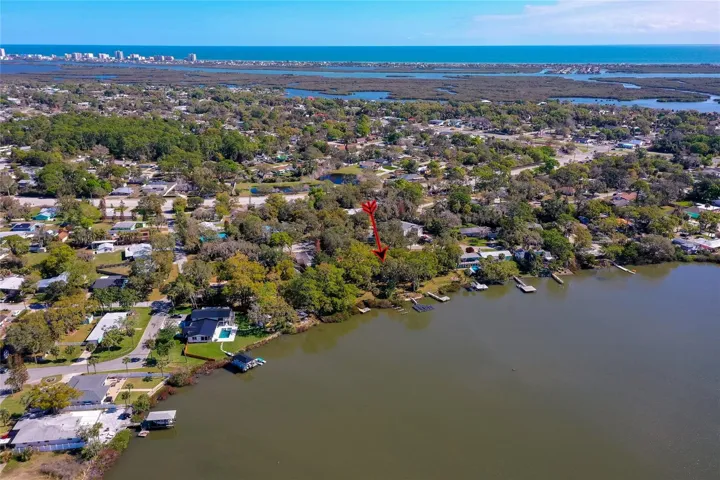 Elevated aerial view showing the home’s waterfront location within the surrounding neighborhood. The setting offers convenient access to nearby waterways and the coast.