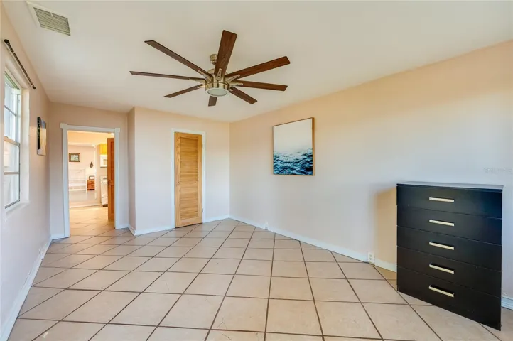 In-law Suite - Spacious room with tile floors, a ceiling fan, and an open layout that offers versatility for a sitting area, studio, or additional living space.