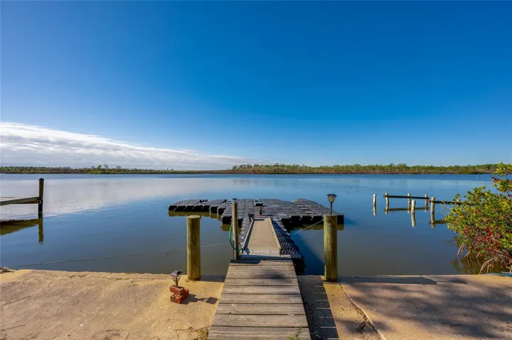 Private dock extending out to calm water views, offering easy access for boating, fishing, or simply enjoying the scenery. The wide-open outlook adds to the property’s waterfront appeal.