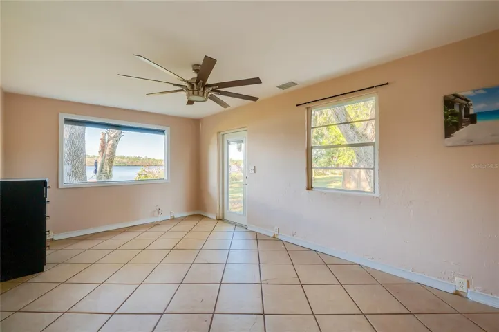 In-law Suite - Bright room with tile floors, large windows, and direct access outside. Water views and natural light make this a standout multipurpose space.