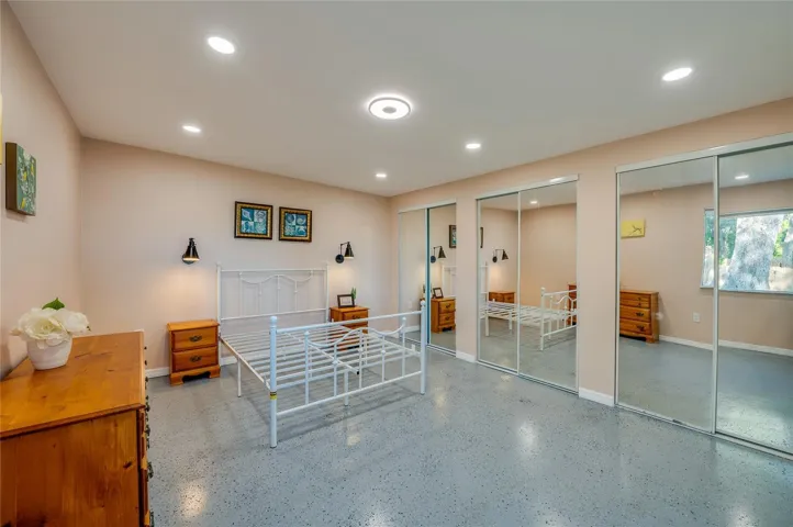 In-law Suite - Spacious bedroom featuring recessed lighting, mirrored closet doors, and a clean, modern feel. The broad layout creates a comfortable retreat.