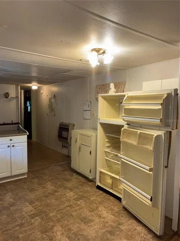 View from kitchen past dining to a bedroom and full bathroom. Door to storage shed and laundry is also off this hallway.