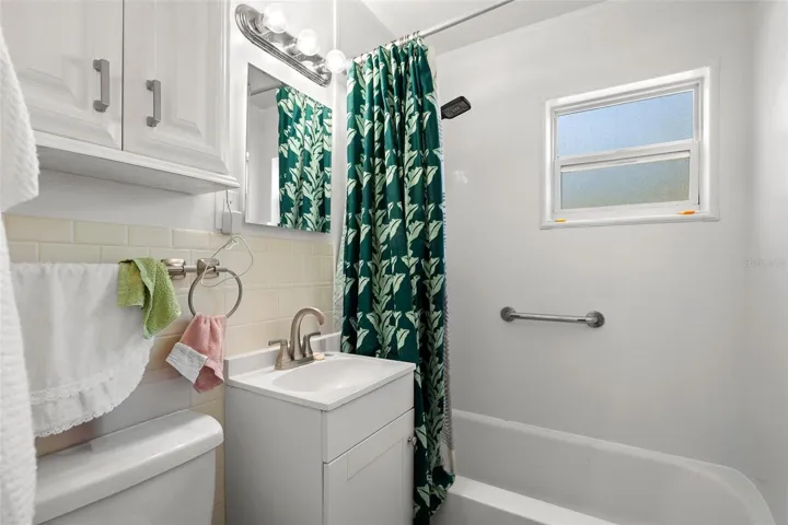 Well-maintained bathroom with a tub/shower combination, updated vanity, and a frosted window that brings in natural light while maintaining privacy.