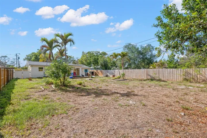 Generous fenced backyard with a wood deck and plenty of open space, offering endless potential for outdoor living, gardening, or entertaining.