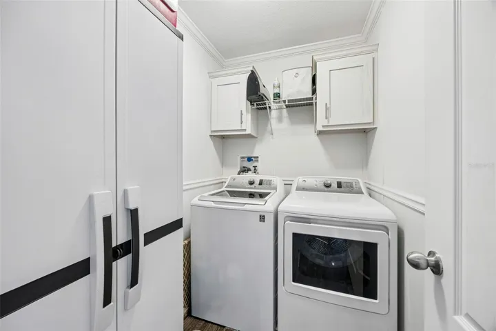 The laundry room is tucked away just inside the front door and also conveys with the sale of this home