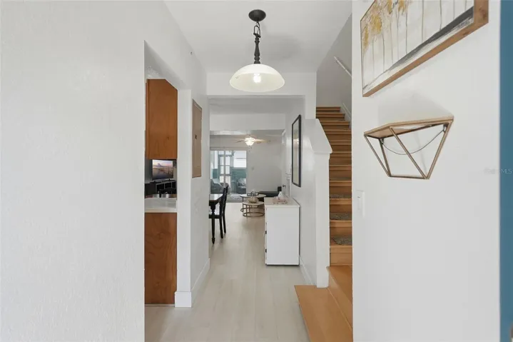 Entry with hardwood stairs on the right and the kitchen on the left
