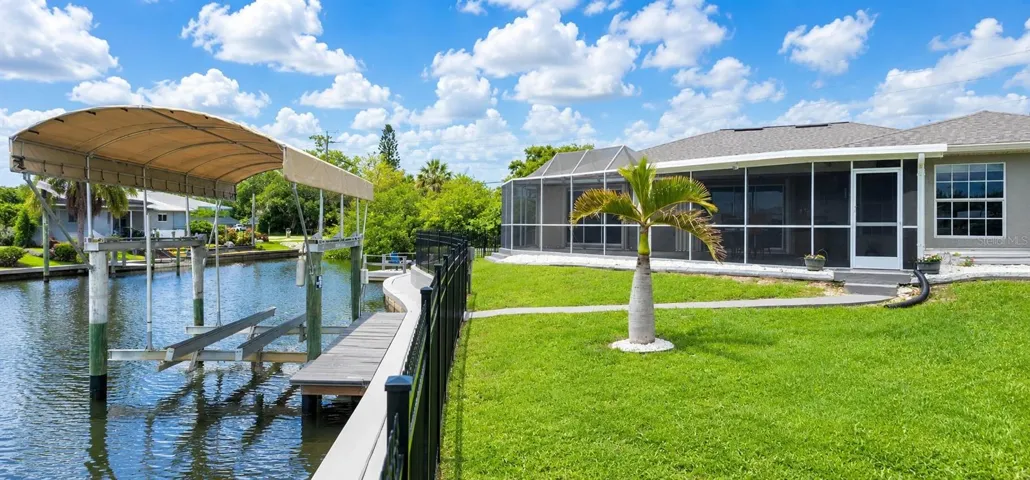 Back of home with view of boat lift