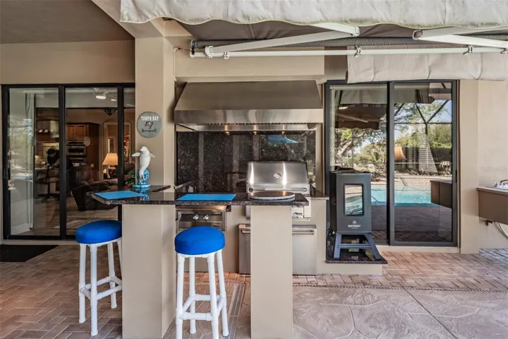 Outdoor kitchen with electric sunshade, smoker and BBQ