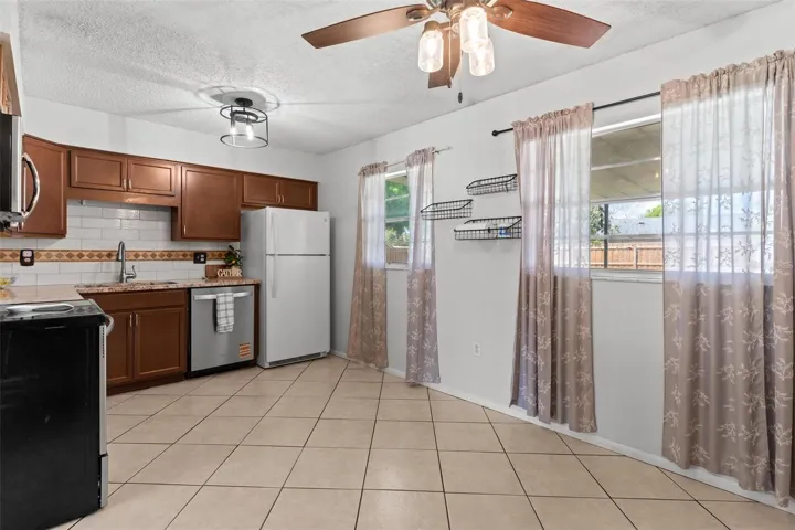 Updated kitchen featuring tiled backsplash.