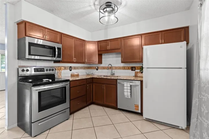Updated kitchen featuring tiled backsplash.