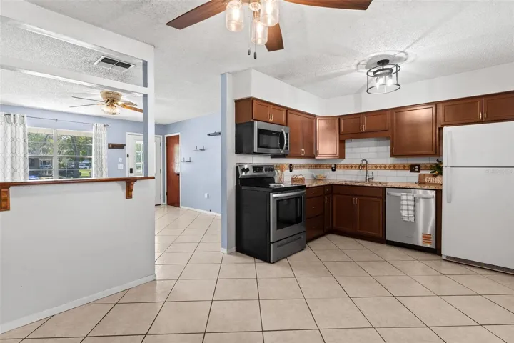 Updated kitchen featuring tiled backsplash.