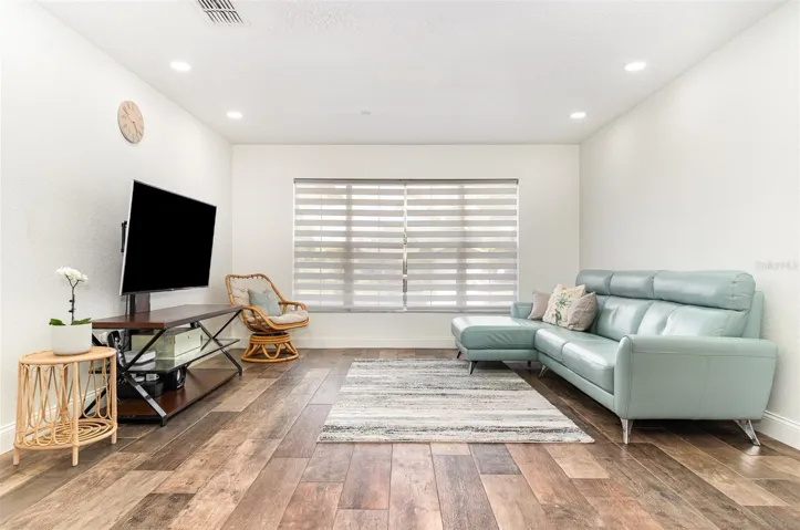 Living area shown with previous owner's furniture to illustrate layout and design potential