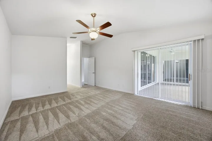 Primary Bedroom with Sliding Door entry to Covered Screened-in Patio