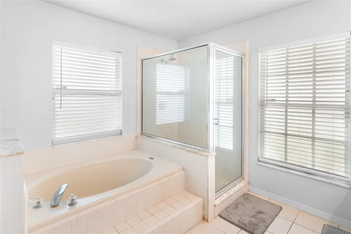 Primary ensuite bathroom features a walk in shower and soaking tub