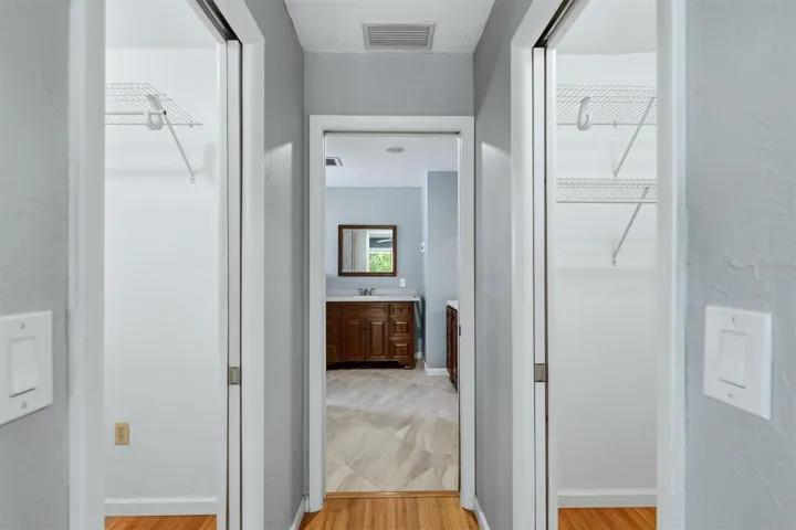 Heading into Primary bathroom with closet on both side