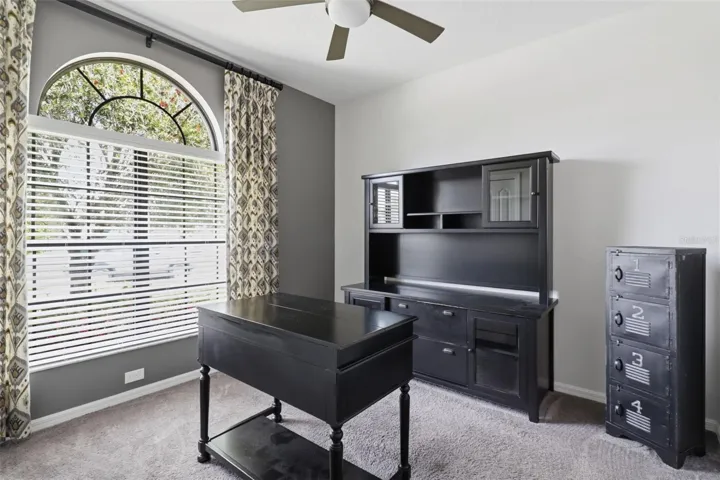 Bright and private room with large arched window, ideal as a home office, guest room, or additional bedroom.