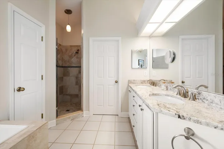 Expansive ensuite bath with dual sinks, walk-in shower, jetted tub, and water closet.