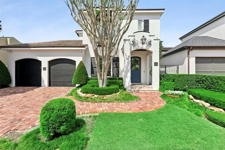 Front of the home, mature landscaping designed and maintained by Signature Landscaping.