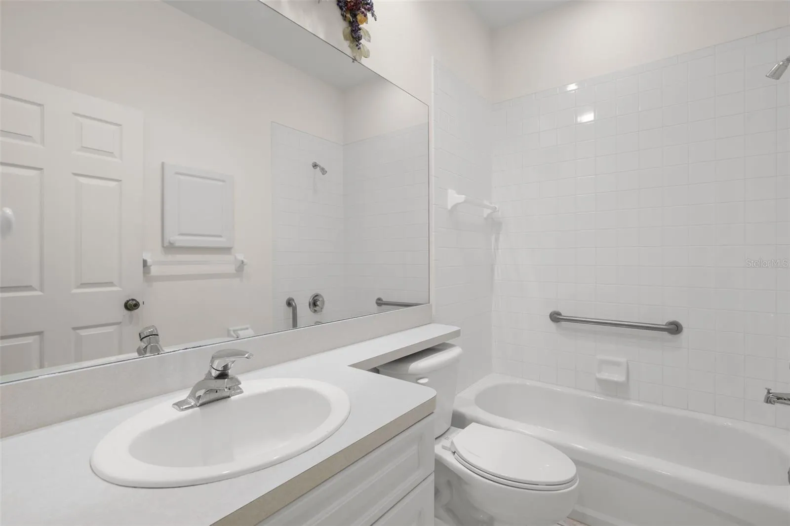 Bathroom 2 with a tub and shower combination, tile surround, and a single-sink vanity, offering a clean and functional layout.