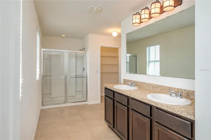 Primary ensuite with dual sinks and step in shower.