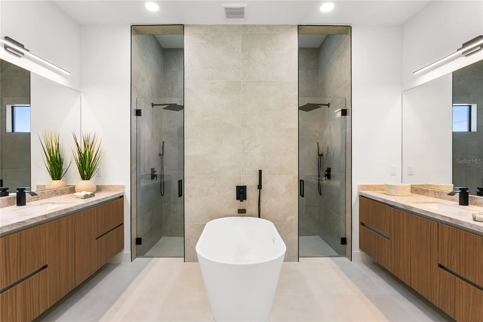 SPA-STYLE BATH featuring dual shower system, freestanding tub & marble vanities